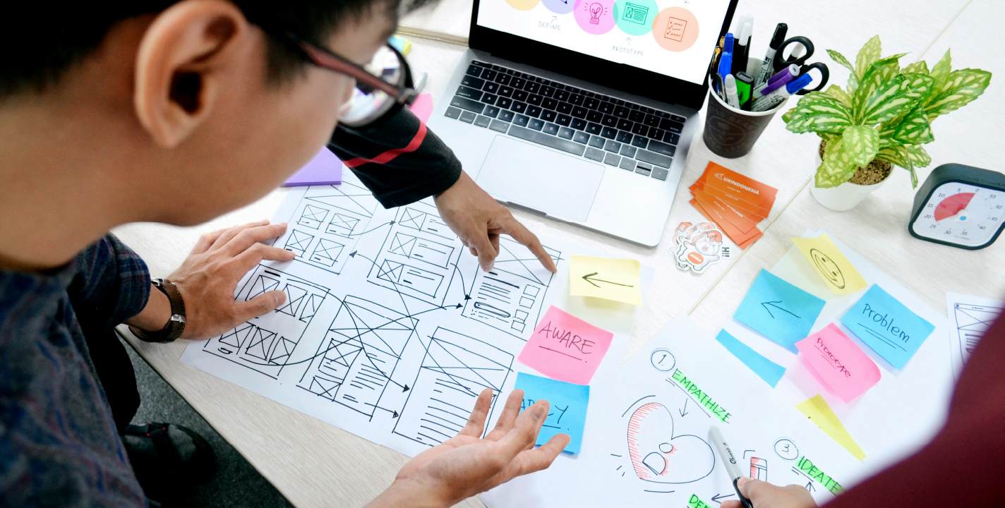 User Interface Design process with wireframes, post-it notes, and laptop