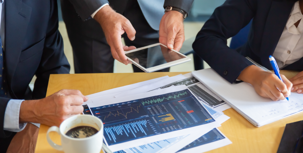 Financial professionals analyzing charts and data on tablet using AWS tools.