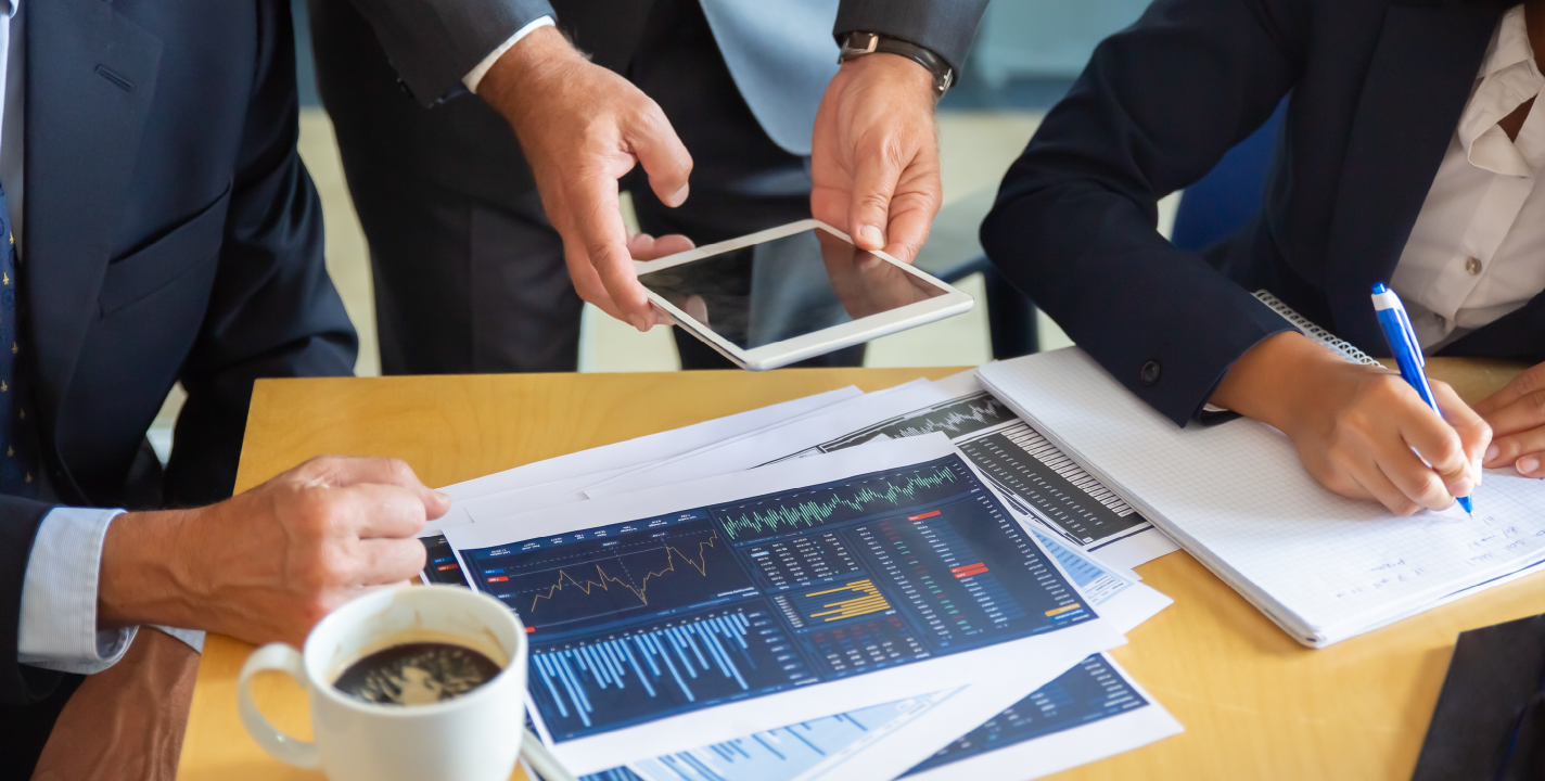 Financial professionals analyzing charts and data on tablet using AWS tools.